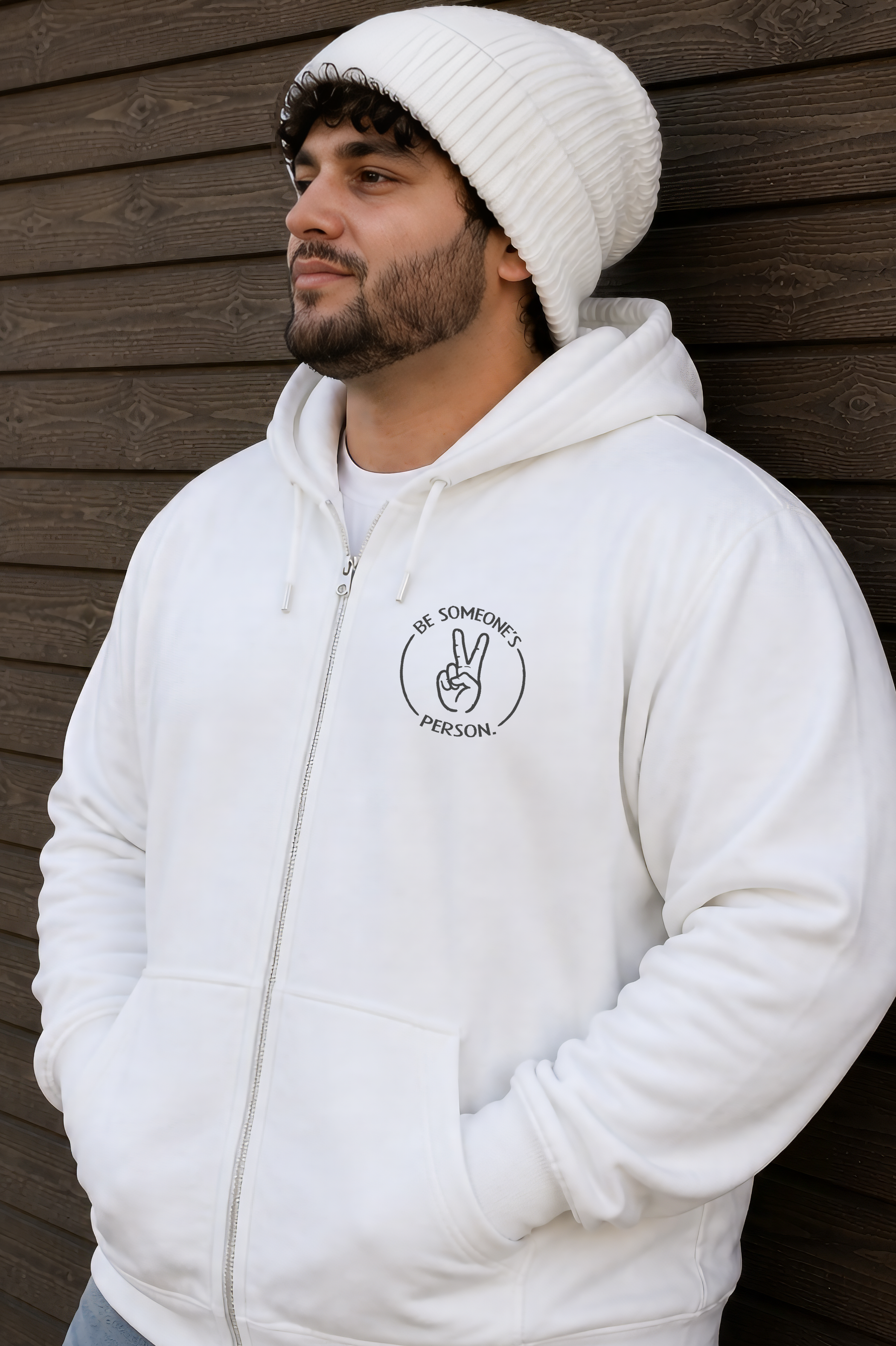 Model wearing a white unisex zip hoodie displaying the classic circular Be Someone's Person peace sign logo, created by content creators Kayla and Samantha.